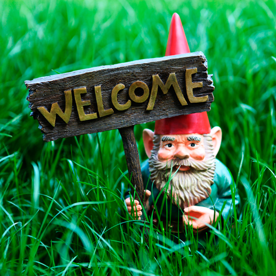 A garden gnome with a welcome sign